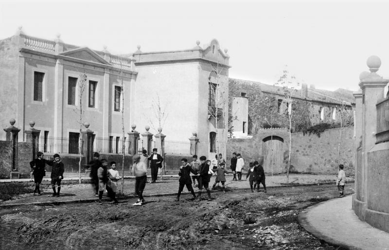 Infants jugant a la plaça de Dolors Clua. Anys 20. AMG.